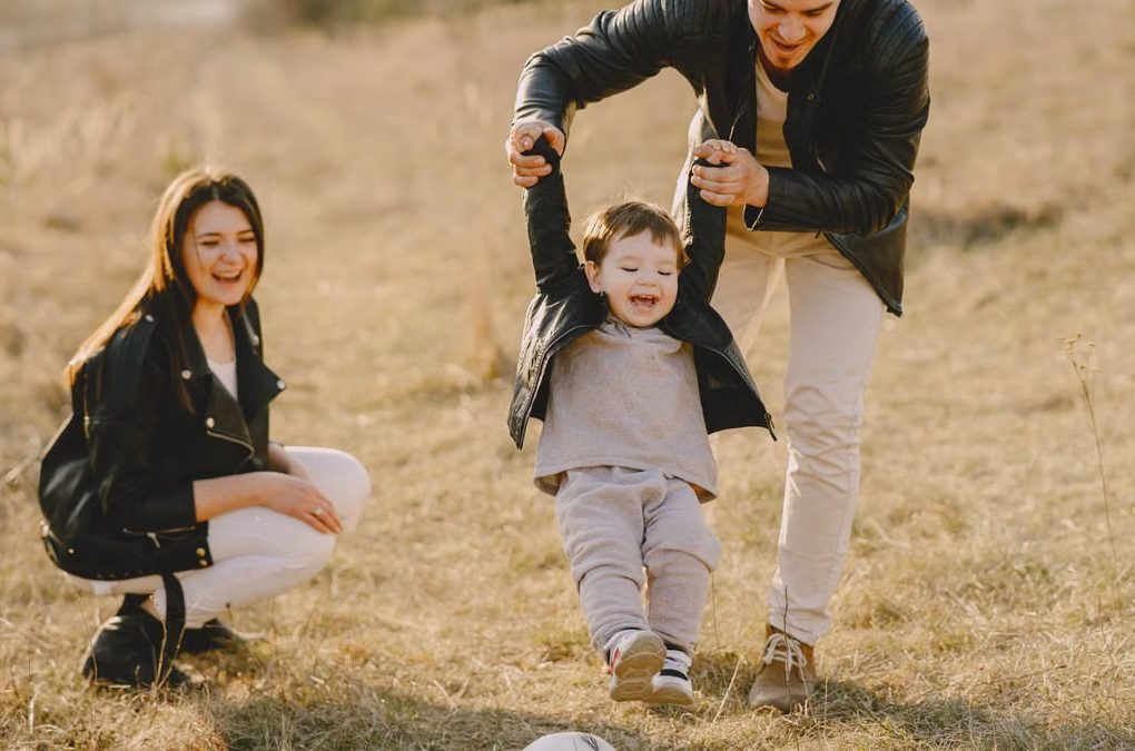 Family enjoying playful soccer game outdoors, capturing joyful moments.