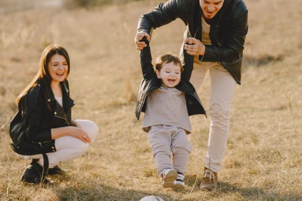 Family enjoying playful soccer game outdoors, capturing joyful moments.